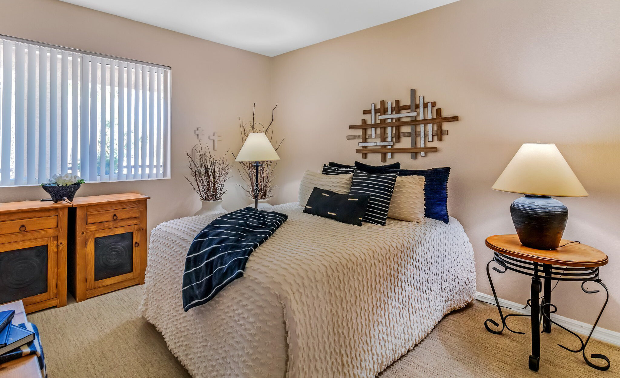 _MG_4431 - The Ranch Estates at Scottsdale A bedroom with a bed, white sheets, and blue throw pillows, with a bedside table and lamps on each side of the bed at The Ranch Estates at Scottsdale.