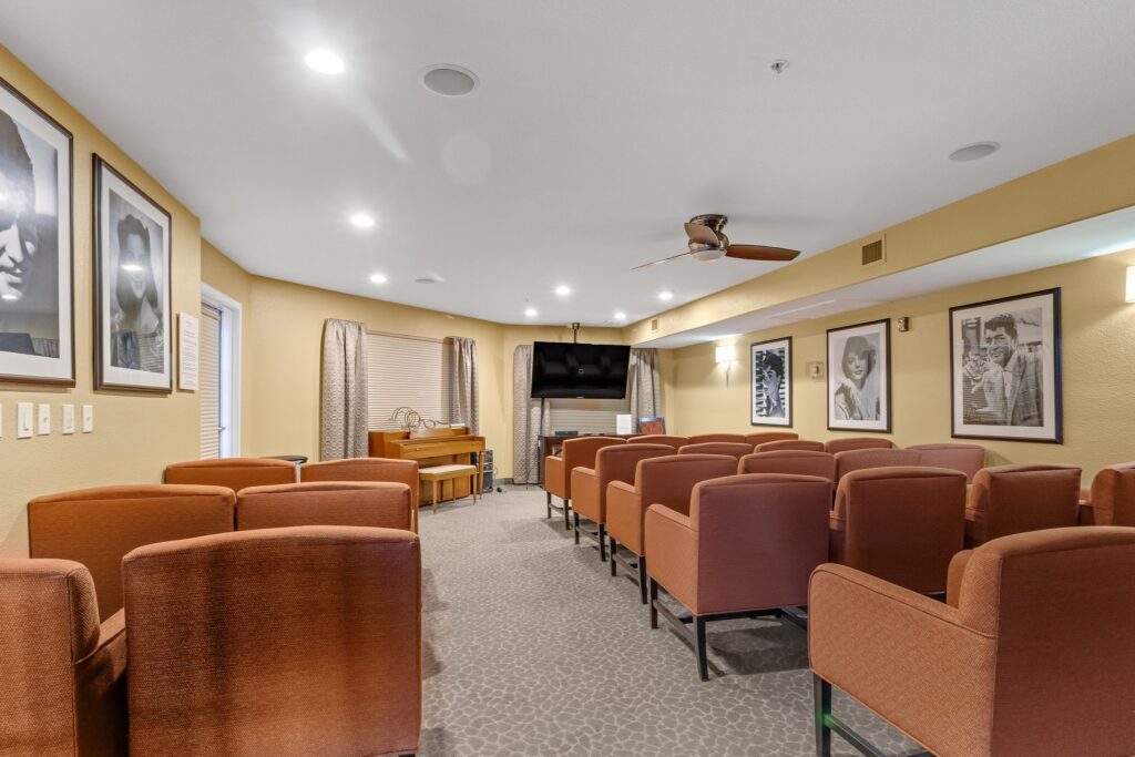 MG_4452 - The Ranch Estates at Scottsdale A sitting area with orange sofa chairs and black-and-white photograph portraits hung up all around the room at The Ranch Estates at Scottsdale.